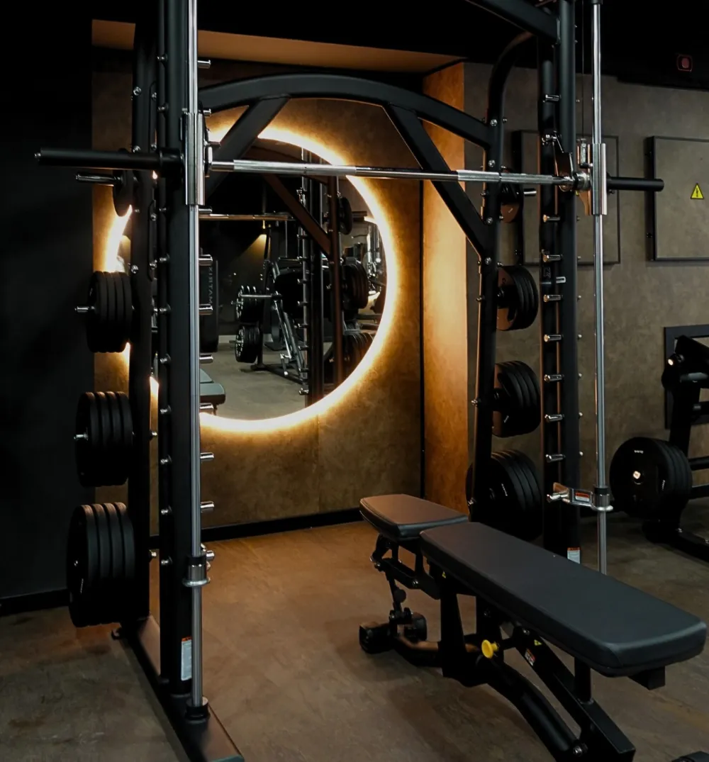 Zona de fuerza de ICROM FITNESS con rack y espejo iluminado